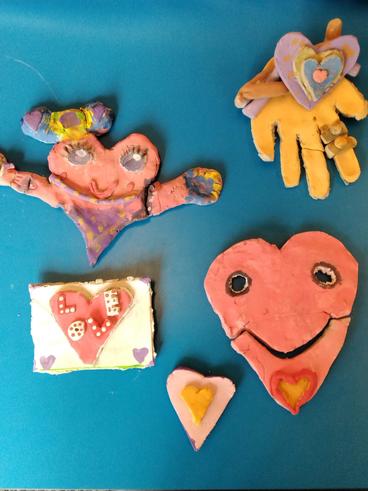 Clay hearts embraced by hands